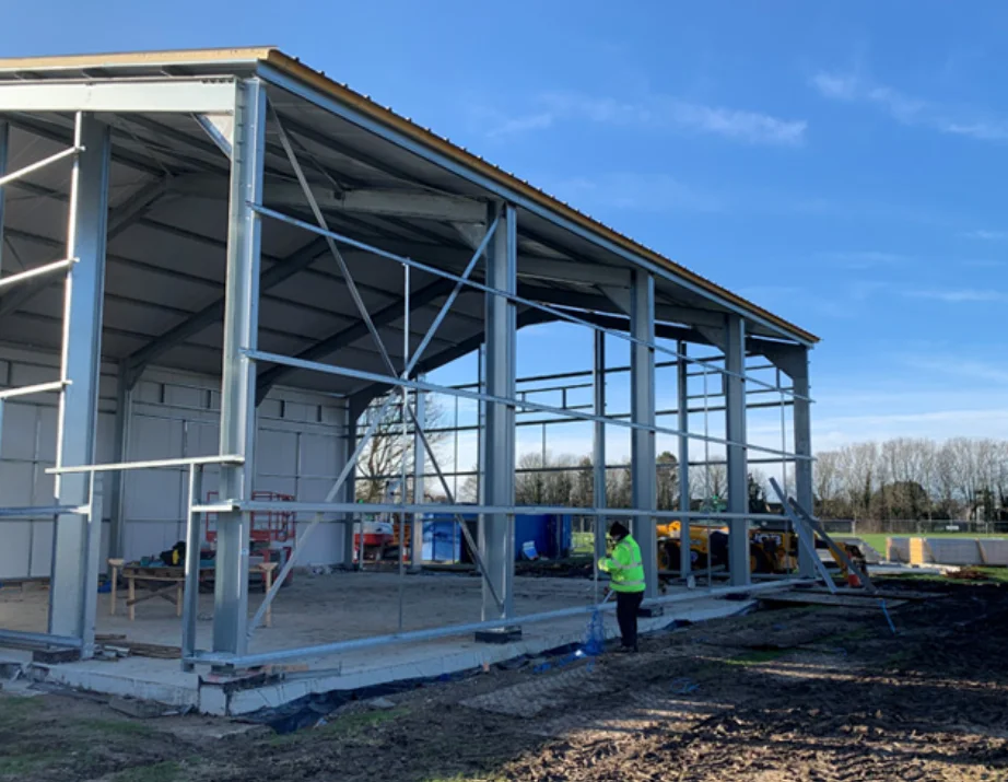 New industrial unit under construction with a galvanised steel portal frame on a concrete slab