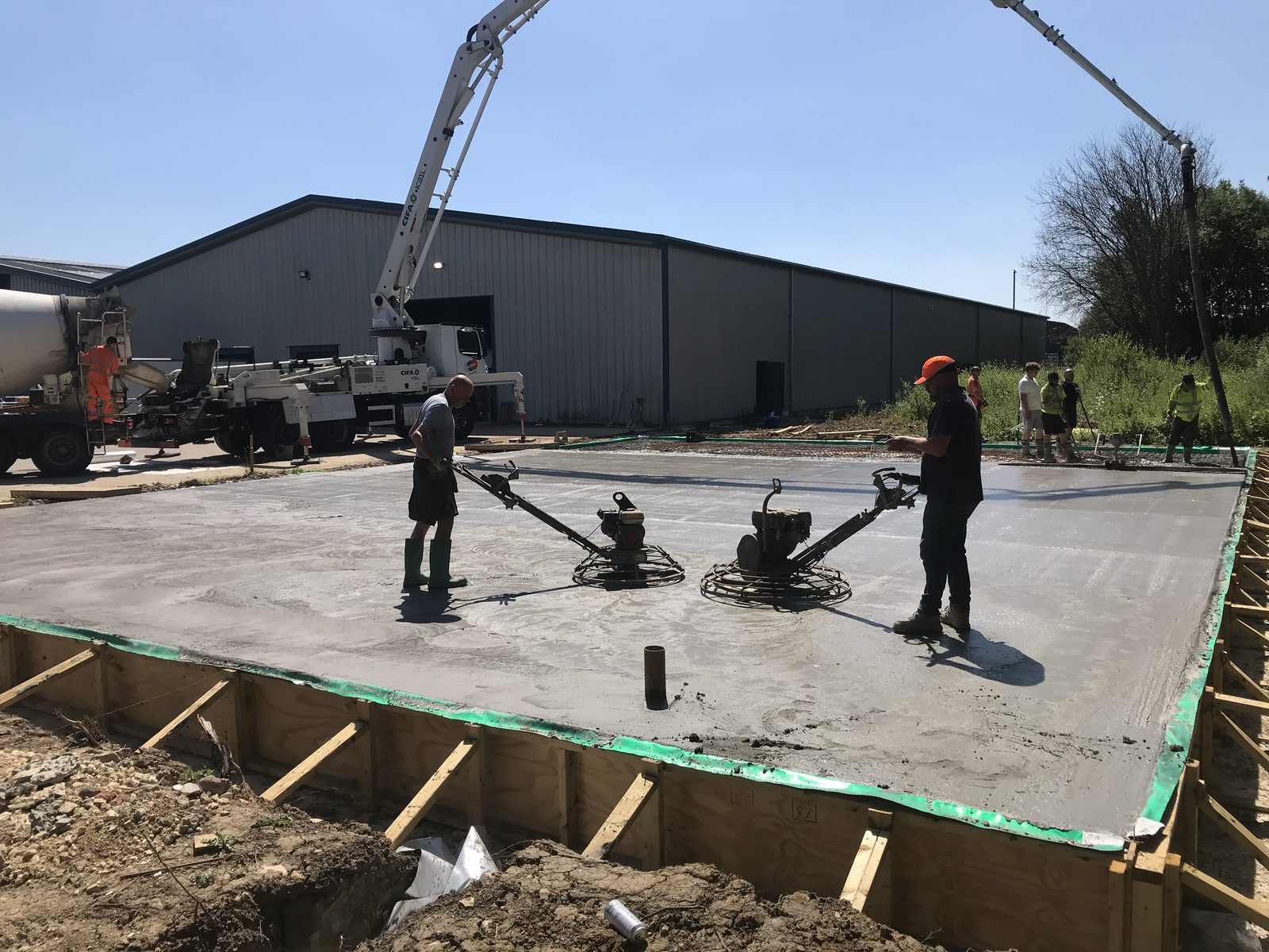 Operatives power floating a freshly poured reinforced concrete slab