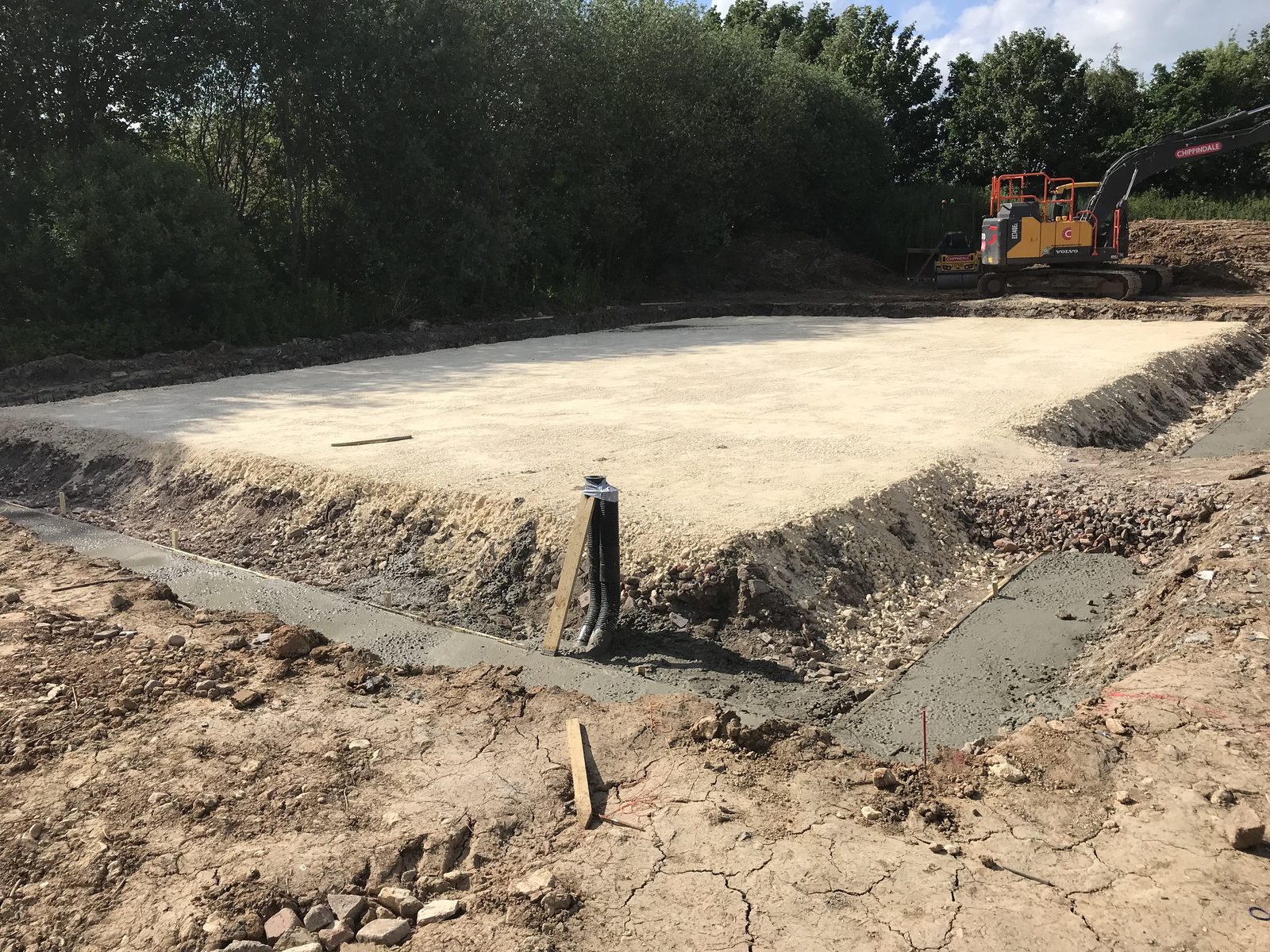 Compacted stone sub-base with freshly poured strip foundations